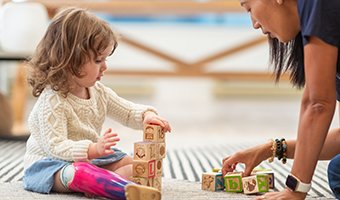 Child stacking blocks in pediatric rehabilitation.