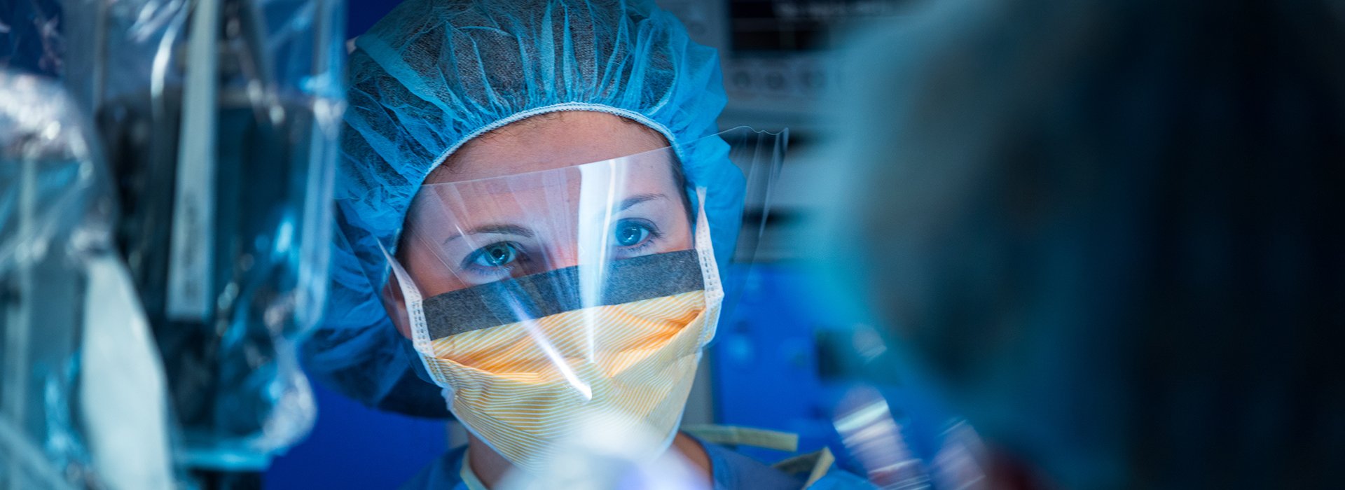 Care provider in scrubs during surgery.