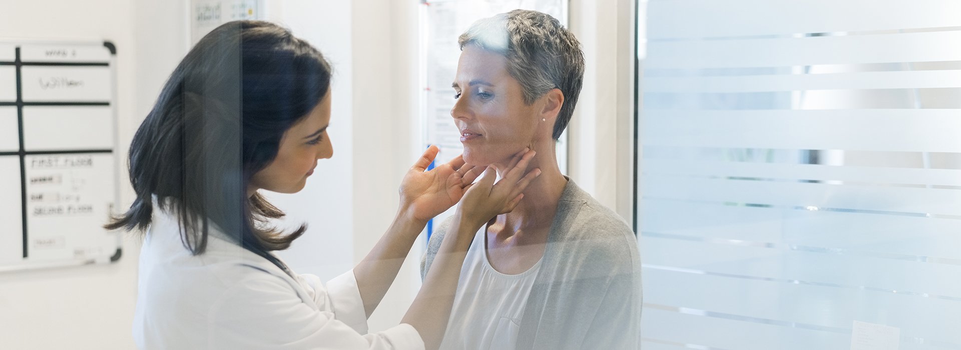 Female doctor in exam room talking to female patient.