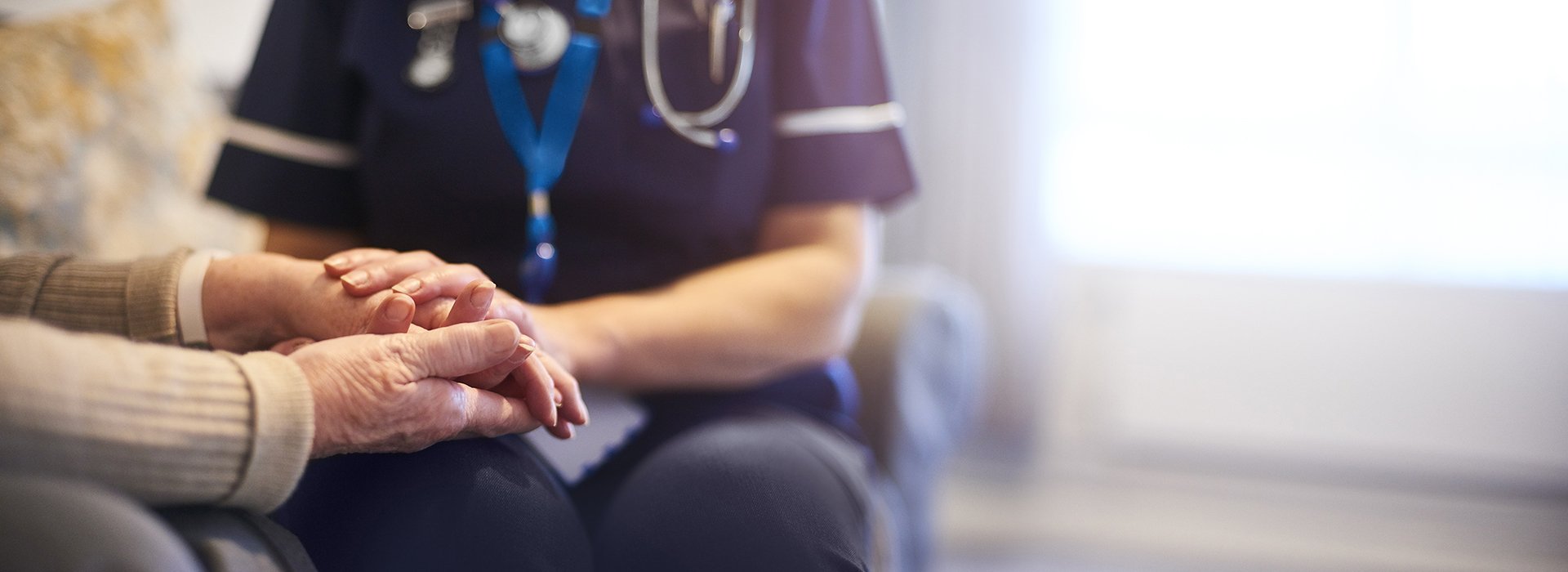 Nurse holding hands of family members.