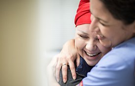 Cancer patient hugging nurse