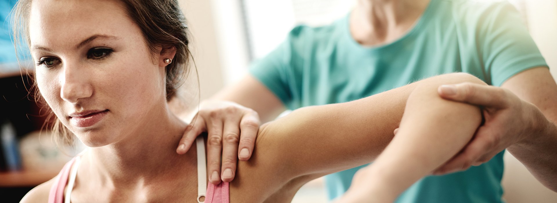 Woman stretching arm with physical therapist