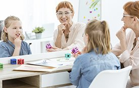 Pediatric speech therapist working with girl.