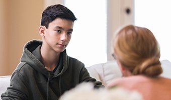 Teenage boy talking to a woman.